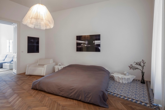 stará budova byt wien posteľ koberec šedá drevená podlaha