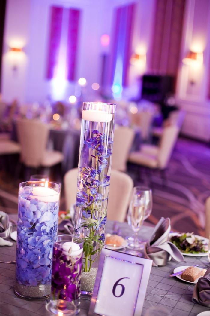 Svadobná dekorácia v svietniku z fialového skla naplneného lístkami kvetov Svadobná dekorácia-vo-fuchsii-biela-sviečka-dekorácia-lístkov-purpurová