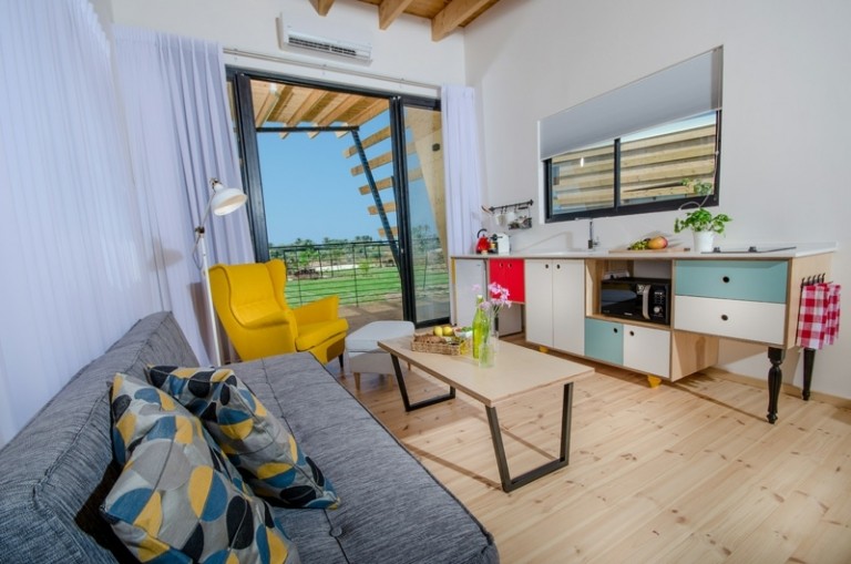 drevená podlahová deka pohovka sivý konferenčný stolík kuchyňa moderné tyrkysové akcenty