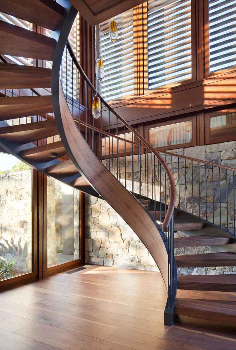 obklad z prírodného kameňa vo vnútri drevené schody závesné svetlá na okná