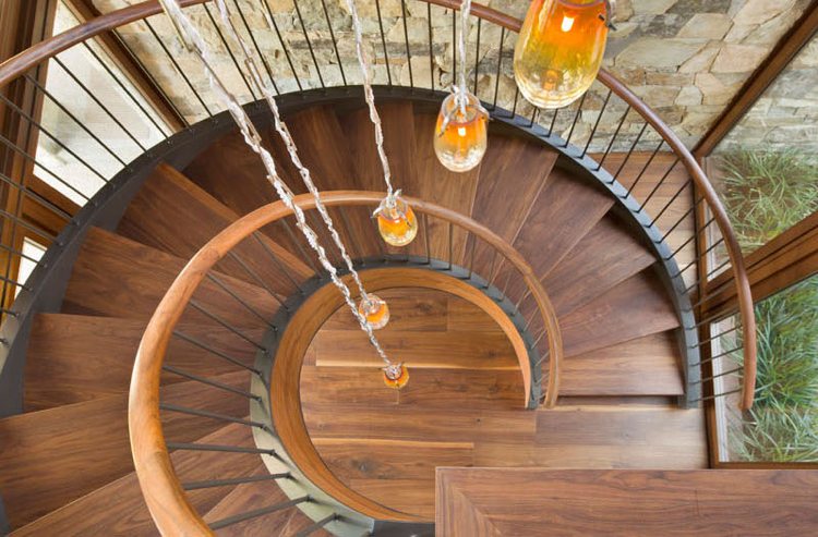 obklad z prírodného kameňa vo vnútri drevené schody točité závesné svetlá sklo