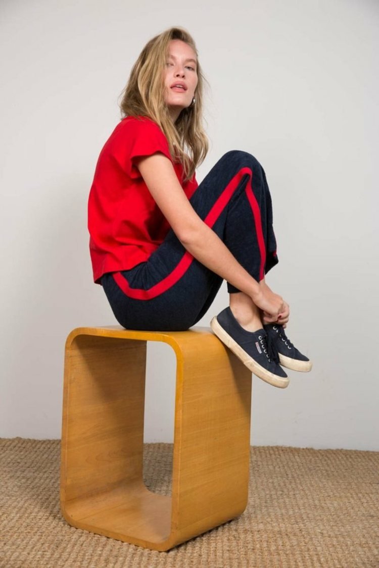 Športové látkové nohavice kombinujú čierne tenisky s oblečením pre ženy