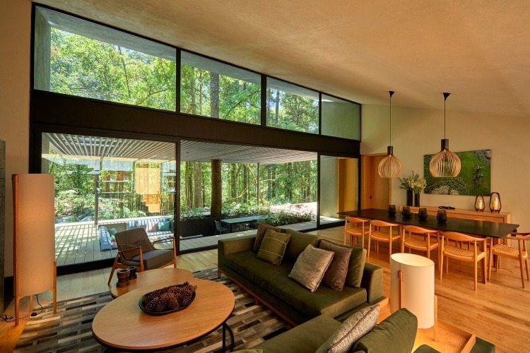 Okrúhly drevený konferenčný stolík v obrovskej obývacej izbe so šikmou strechou