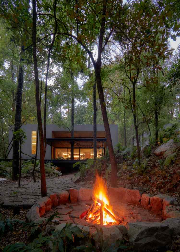 malé ohnisko obklopené stromami a chatami v lese