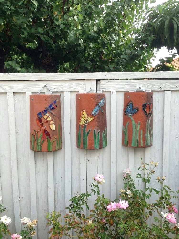 umenie na starých strešných tigroch s farebnými figúrkami visiacimi na záhradnej stene