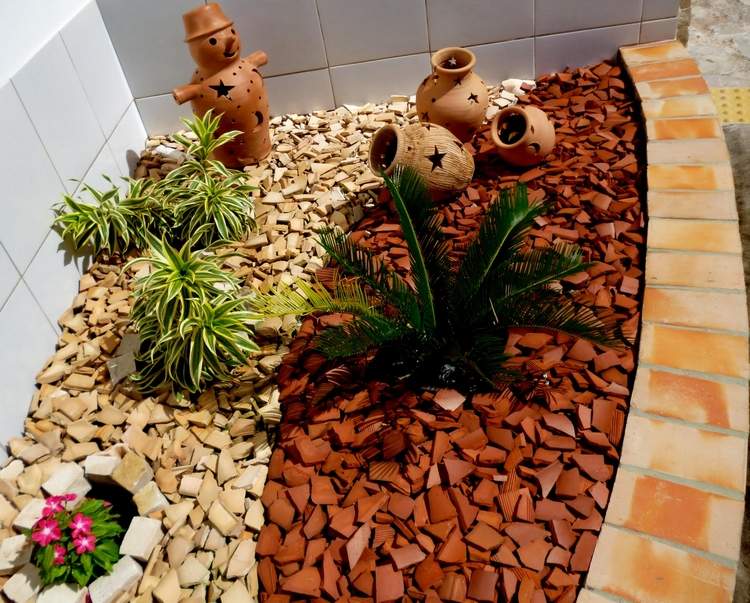 Rozbite červené a béžové staré strešné tašky na kúsky a recyklujte ich ako ohraničenie v záhrade