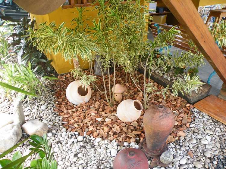 staré strešné tašky rozbité na časti ako rozdeľovače miestností v záhradnej oblasti s rustikálnym vzhľadom