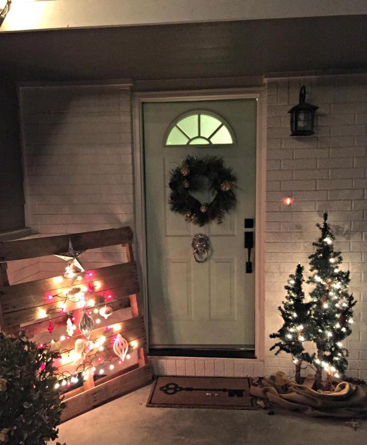 kreatívne navrhnite umelé malé vianočné stromčeky vianočná dekorácia-vonku-osvetlené-domové-dvere-europaletové-svetlá-nápadité-tehlová stena