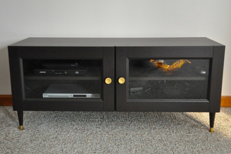 Polica Ikea Besta v čiernej farbe s pozlátenými prvkami ikea-besta-policovy-ulozovy-system-cierny-kredenc-konzola-zlate-akcentove prvky