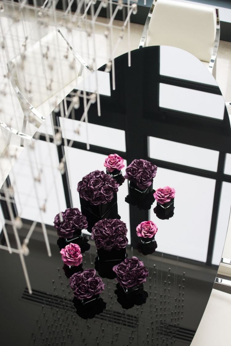 elegantný oválny jedálenský stôl z čierneho skla krásne ozdobený ozdobnými kvetmi priemyselno-elegantný-luxusný-podkrovný-nábytok-stôl-oválny-čierny-vysoký-lesk-ružový-fialový