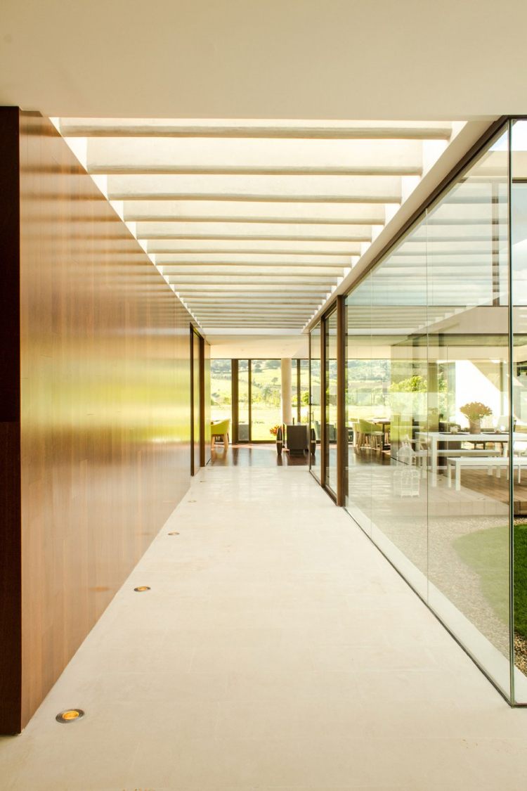 Sklenená deliaca stena-interiér záhrada-luxusný dom-chodba-obklad steny-drevo-denné svetlo