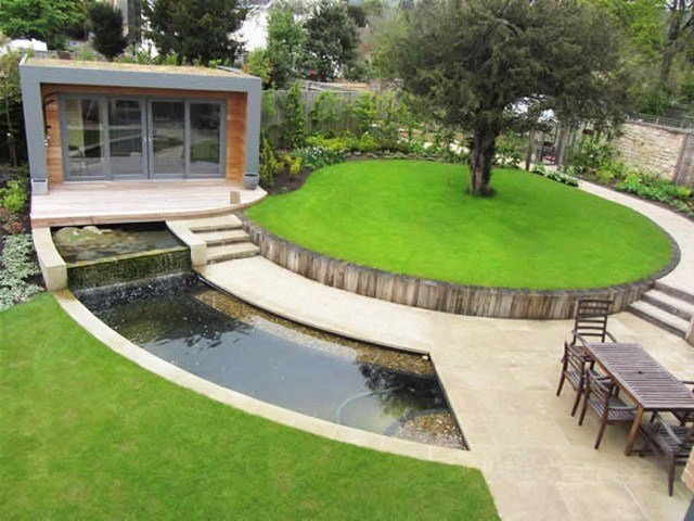 Biele dlaždice kontrastujú s trávou okrúhly-záhradný-dsign-design