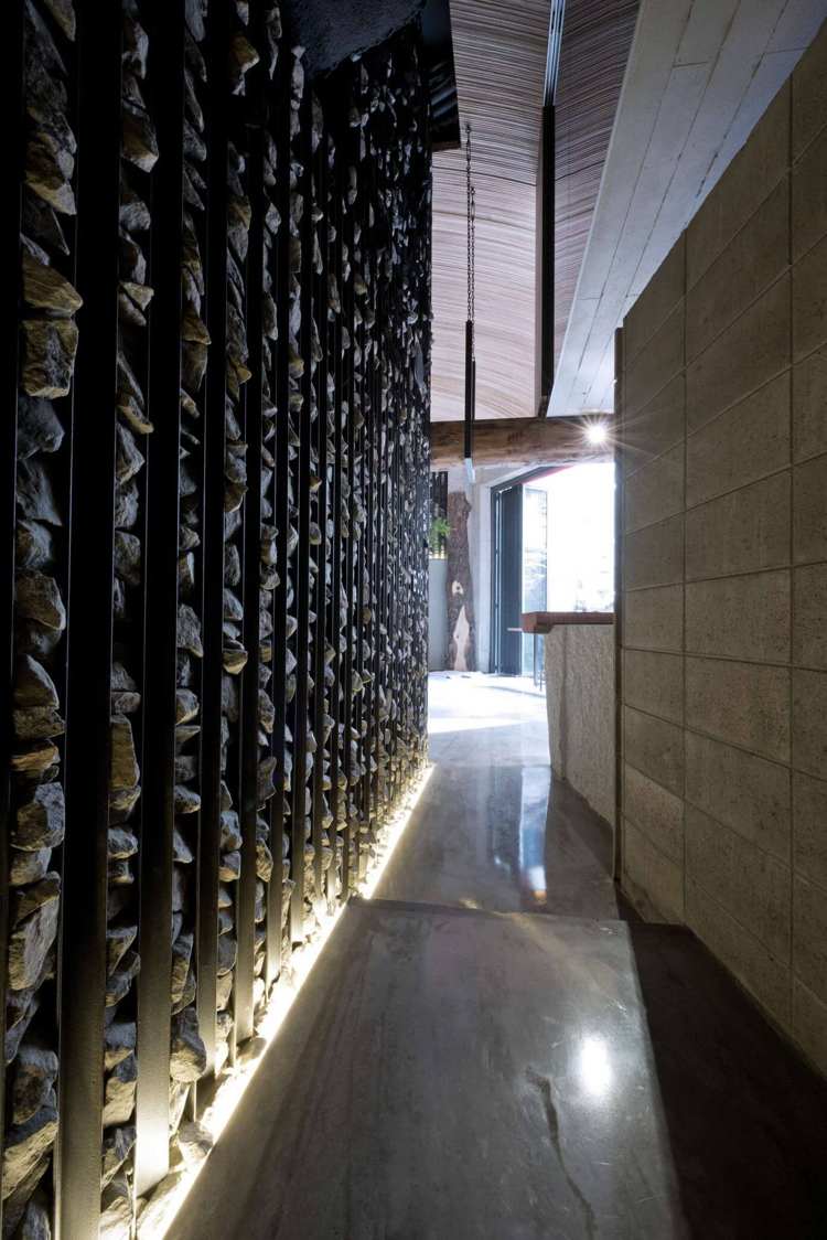 exkluzívny, lineárny dizajn steny vyrobený z ocele a lomového kameňa interiérový trend-moderný-kamenný-obklad-steny-ozdobný-lomový-kameň-nepriame-osvetlenie