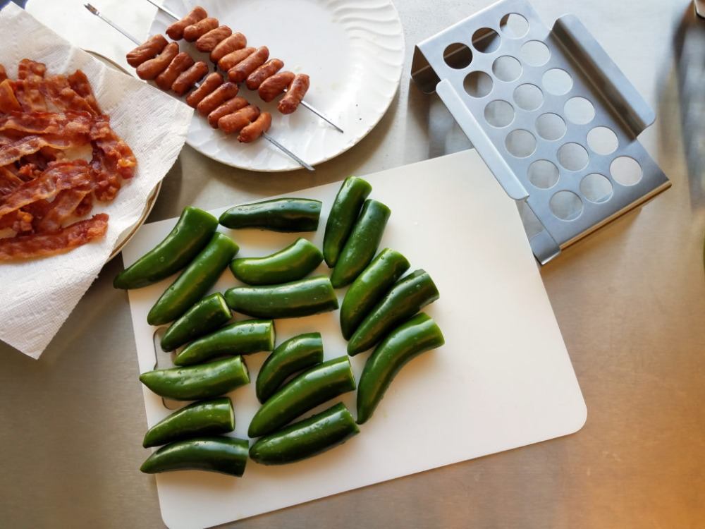 opražené plátky slaniny a párky v kombinácii so zelenou chilli papričkou na kuchynskej doske