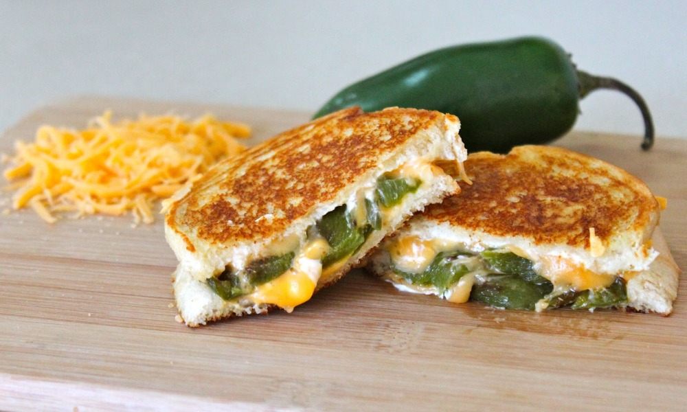 sendvič s grilovaným syrom s jalapeno poppermi a syrom čedar, ako aj plátky slaniny a masla