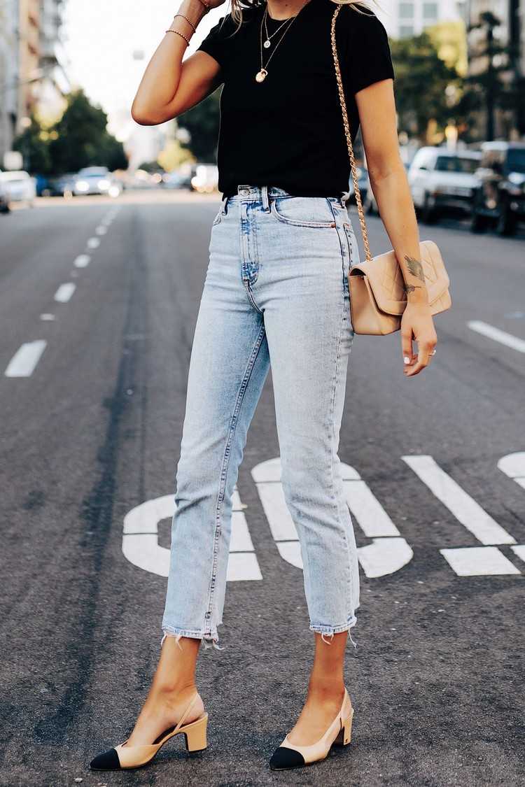 Noste rovné rifle vo svetlo modrej farbe s čiernym tričkom a nahým vreckom