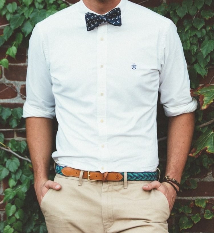 Béžové nohavice, opletený opasok, biela košeľa a motýlik ako príslušenstvo