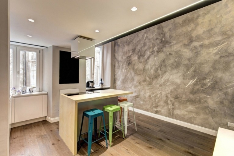 kuchynský dizajn v bielom ostrovčeku s vysokým leskom, farebná taburetka