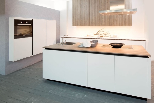 Vybavený kuchynský ostrovček, skrinky bez úchytiek, digestor, drevený pracovný pult, matná biela Vstavaný kuchynský ostrovček, skrinky bez úchytiek, digestor, drevená doska, predné diely v bielej farbe