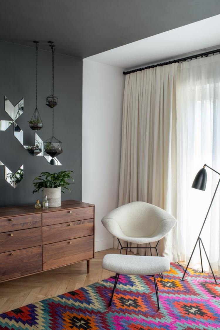 farebný koberec a pokojný interiérový dizajn Kilim-koberec-moderná-komoda-kredenc-drevené-kreslo-diamantová-stolička-biela-lampa na čítanie