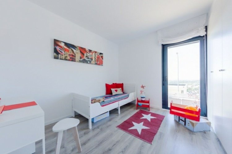 zariadenie detskej izby-jednoduchý-interiér-biely-nábytok-koberec-červená