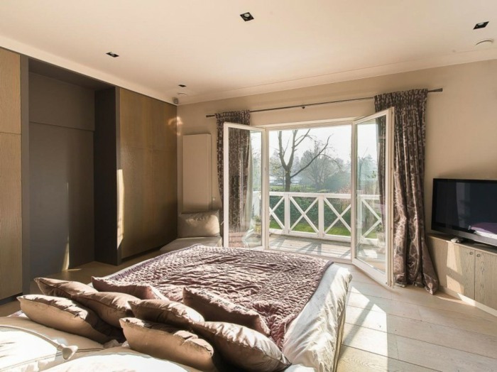 Svetlá laminátová podlaha s drevenou stenou a manželskou posteľou