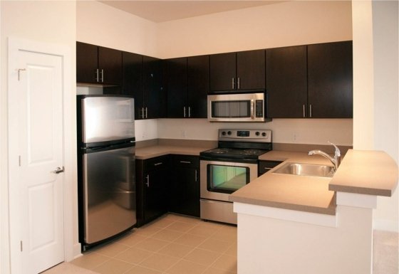 svetlá farba steny s tmavým kuchynským nábytkom chladnička s kovovým vzhľadom moderný-interiér-kuchyňa-dizajn-nápady