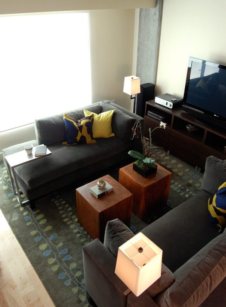 malé sedačky umiestnené oproti sebe v obývačke malé pohovky-sivé-protiľahlé-ležiace-drevené-konferenčné stolíky