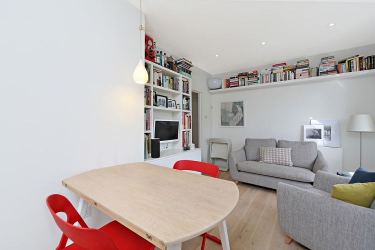 Škandinávska zariadená obývacia izba v sivobielej farbe malé pohovky-obývacia izba-sivé-škandinávske-poličky na knihy