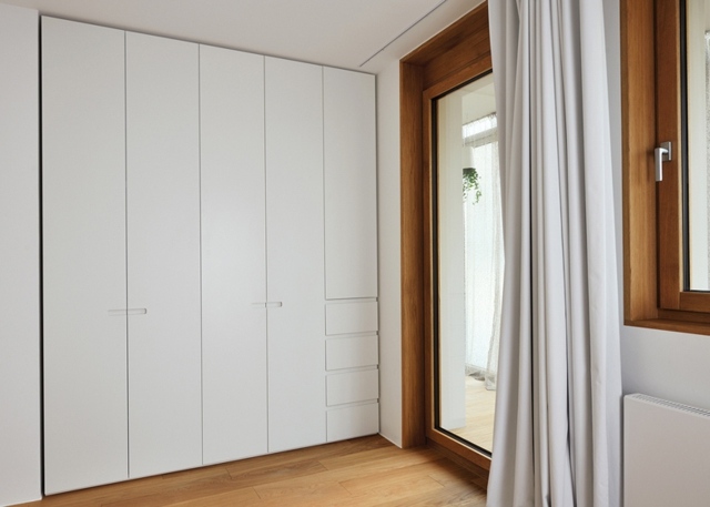 Biela zárubňa z dreveného šatníka, ktorá šetrí miesto