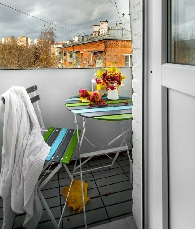 malý balkón zriadený drevený stôl jesenné kvety nastaviť drevený stôl jesenné kvety skladacie stoličky dlažba