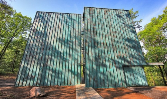 Medený obklad-moderný obytný dom postavený v lese na svahu