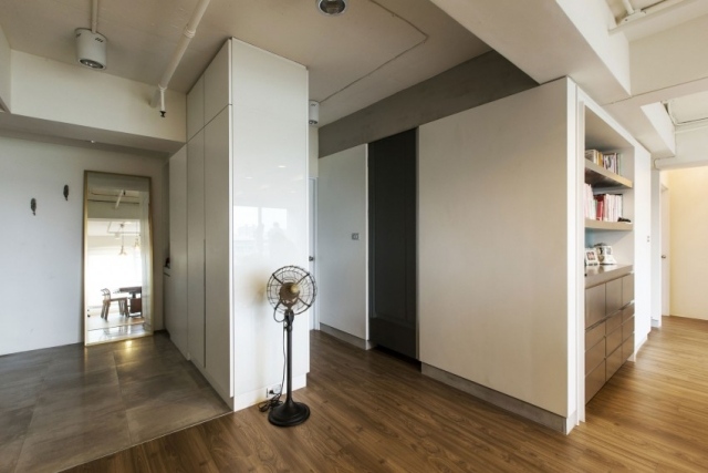 Vstupná časť prepojená so zvyškom bytu bez stien malý-byt-v-tečúcich-izbách-biela-skriňová-sústava