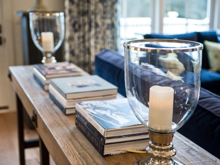 pekná dekorácia na konzolovom stole za pohovkou Konzolový stôl za sedačkou - nápady na zariadenie - knihy - sviečky - držiaky na sviečky - drevený gauč