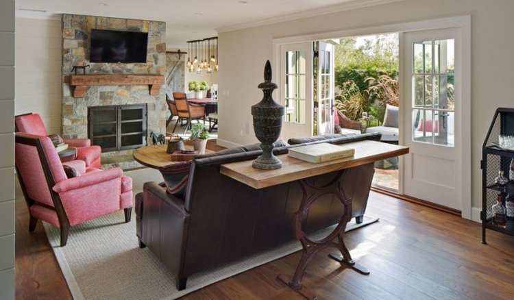 Mix štýlov v obývačke - kreslo v ružovej farbe, krb obložený prírodným kameňom Konzolový stôl za sedačkou-nápady na dekoráciu-jutový koberec-parketová podlaha-krb-prírodný kameň