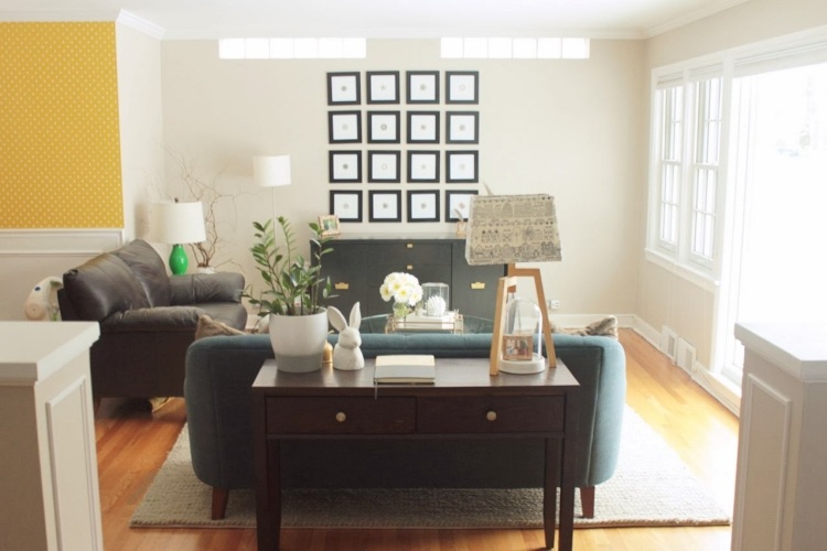 Na konzolový stôl položte stolnú lampu, rastliny a knihy konzola-stol-za-sedaciou-sedaciou-vyrobkou-myslienkami-pohovky-obraz na stenu-tmavohneda-stena-dizajn-zlta-latka