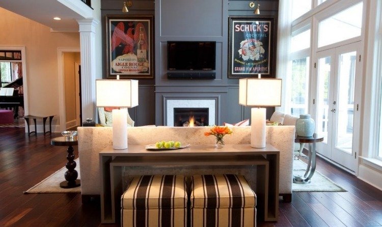 Zaujímavo zariadená obývačka so symetricky usporiadanými kusmi nábytku konzola-stol-za-sedackou-sedackou-predstavy-plagaty-lampy-elegantna-stolickova-pruhy-polstrovanie