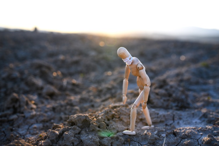 unavený drevený muž s ochrannou maskou na skalách