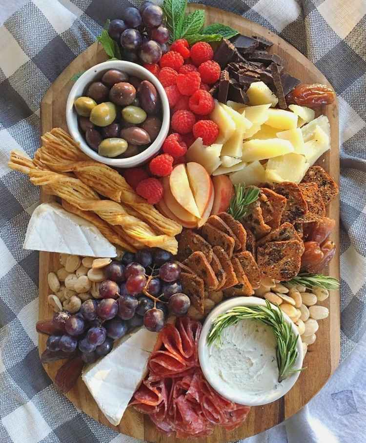 Pekný syrový tanier s orechmi, ovocím a smotanovým syrom Poukladajte dosku na krájanie na syr-obrus-salámy-orechy-rozmarín-olivy-hrozno-maliny-datle-bylinky-mäta-1