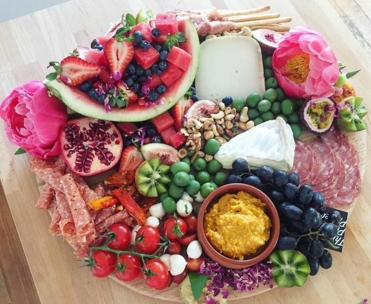 Okrúhly tanier so syrom s nakrájaným ovocím, zeleninou a kvetmi ako ozdoba syr-tanier-servírovanie-dip-kvet-ovocie-melón-kiwi-saláma-grisini-čučoriedky-viničové paradajky-granátové jablko-9