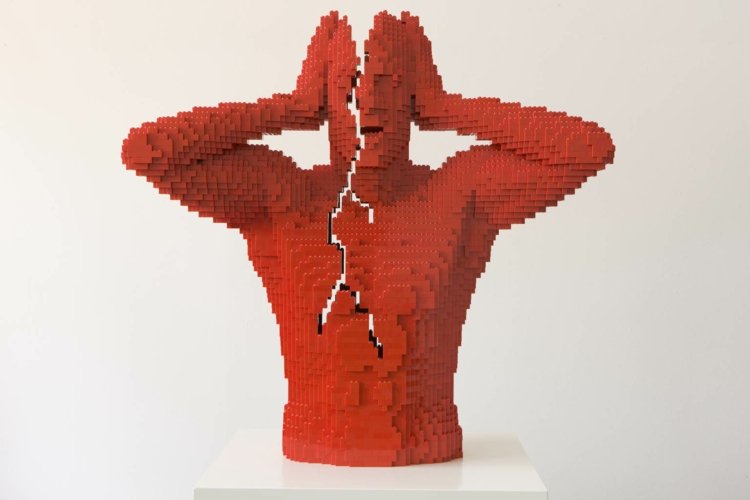 Vypracovaná postava sa zdá, že sa trhá na dve časti art-lego-break-crack-red-socha-plast
