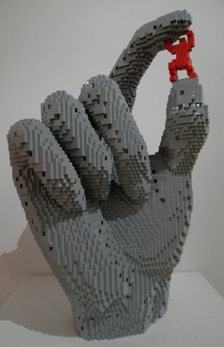 Umelecký nápad s veľkou rukou a malým človekom umenie-lego-sila-ducha-ruky-človeka-maličkého