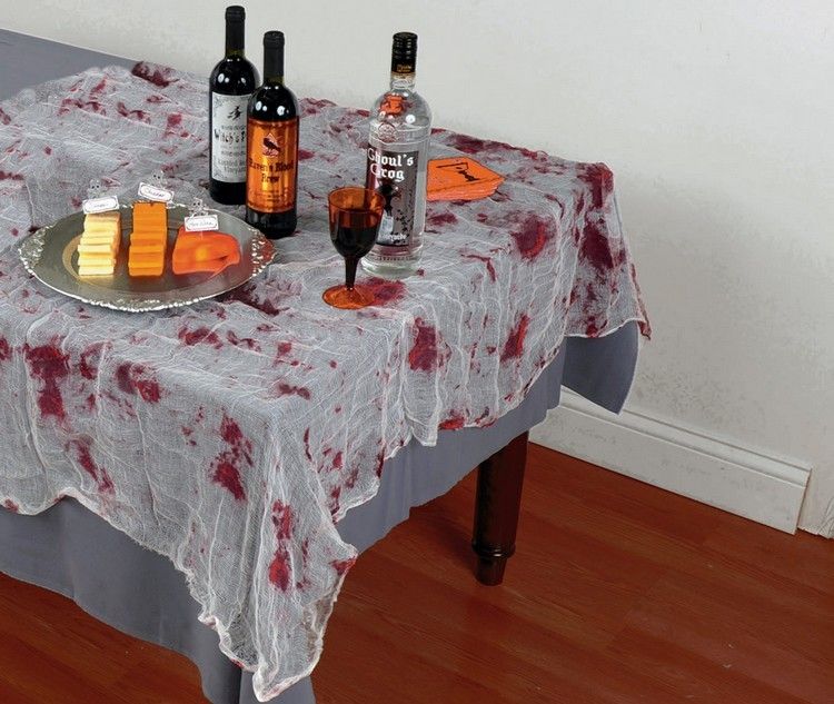 Nápad na dekoráciu stola na Halloween s gázovými obväzmi halloween-dekorácie-stola-gázy-obrusu-červených-škvŕn-krvi