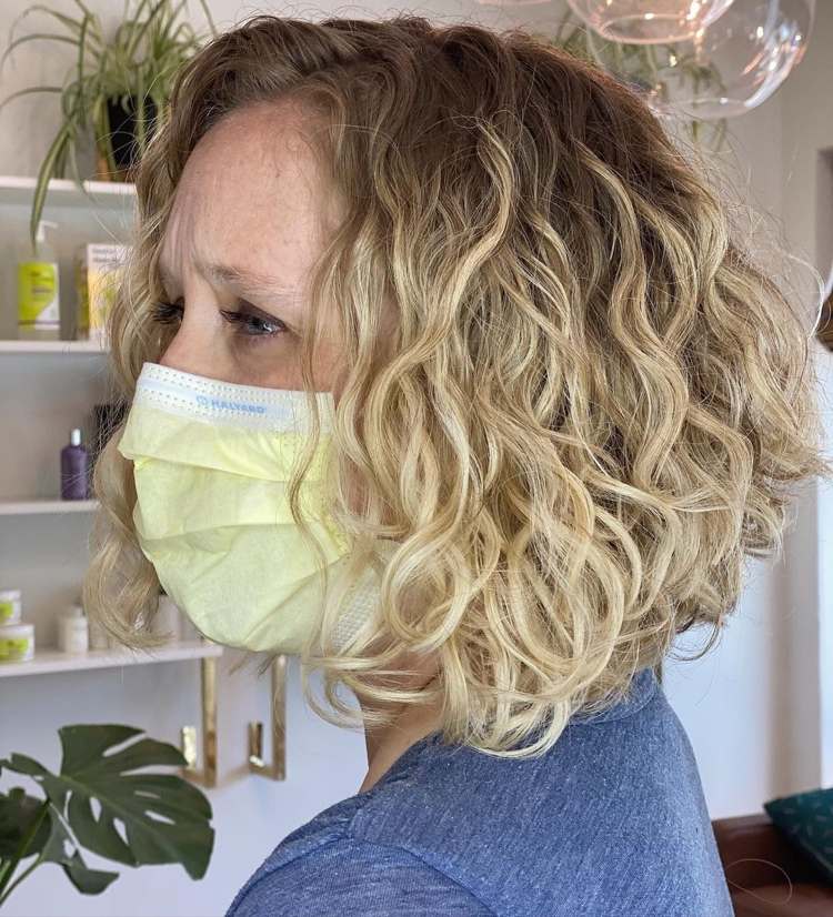 kučeravá hlava s asymetrickým účesom bob