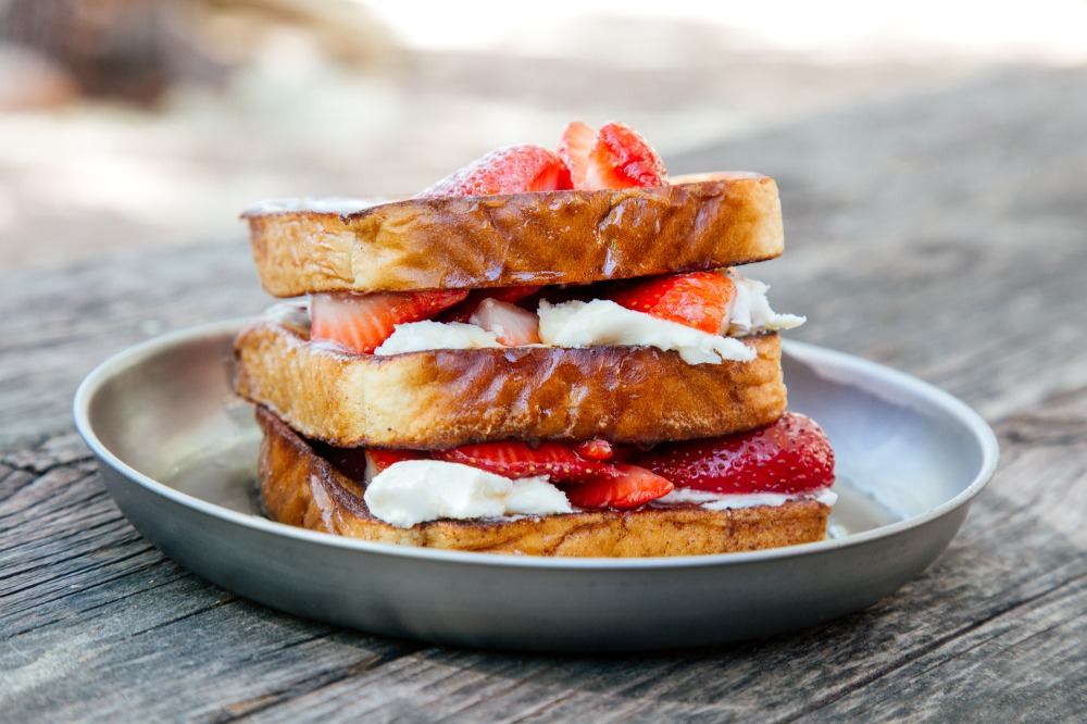 chudobní rytieri pripravujú recepty vonku s maslom a jahodami ako táborák