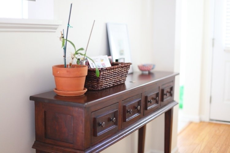 Tabuliek pre konzoly je veľa a je na nich miesto pre malé predmety alebo obrázky vidiecky nabytok-na-chodbe-nabytok-konzola-stol-drevo-tmavo-zasuvky-rastlinny-kosik-ratan