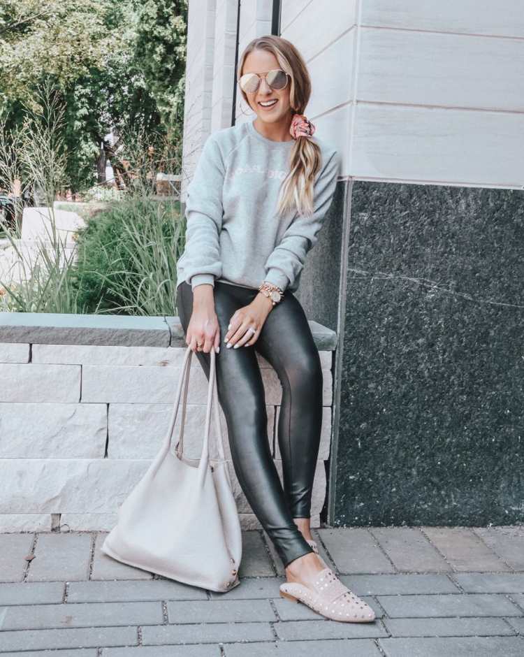 Kožené legíny športový outfit so svetlo zeleným svetrom a béžovými mokasínami