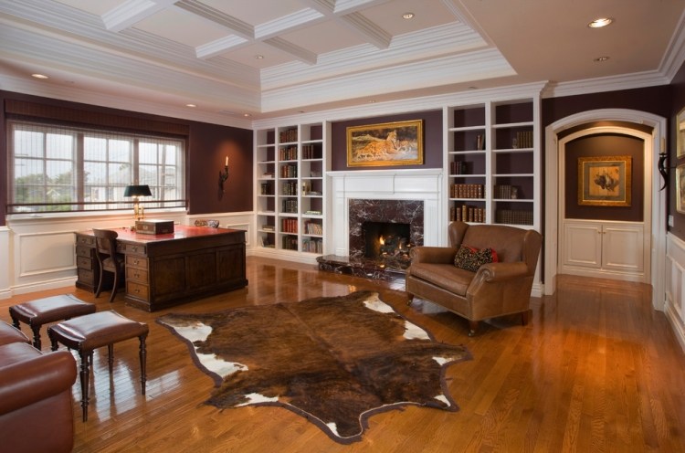 Obývacia izba zariadená kobercom z hovädzej kože a kreslom Kožené kreslo-hnedo-hovädzia koža koberec-biele-nástenné police-krbové dvere-oblúkové dvere