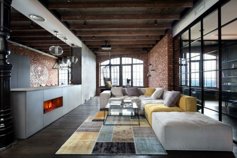Podkrovie má typické tehlové múry a drevené obklady loft so sivým nábytkom moderný svetlo šedý sedací patchwork koberec