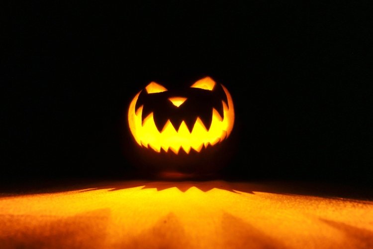 Tvár Halloweenskej tekvice pri strašidelnej lampióne v noci